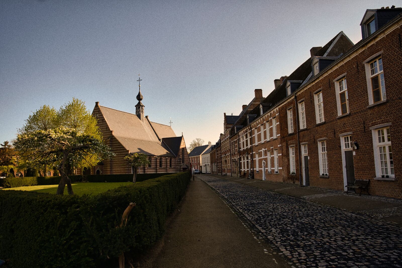 Kopfsteinpflastergasse mit Kirche im Abendlicht in Alkmaar